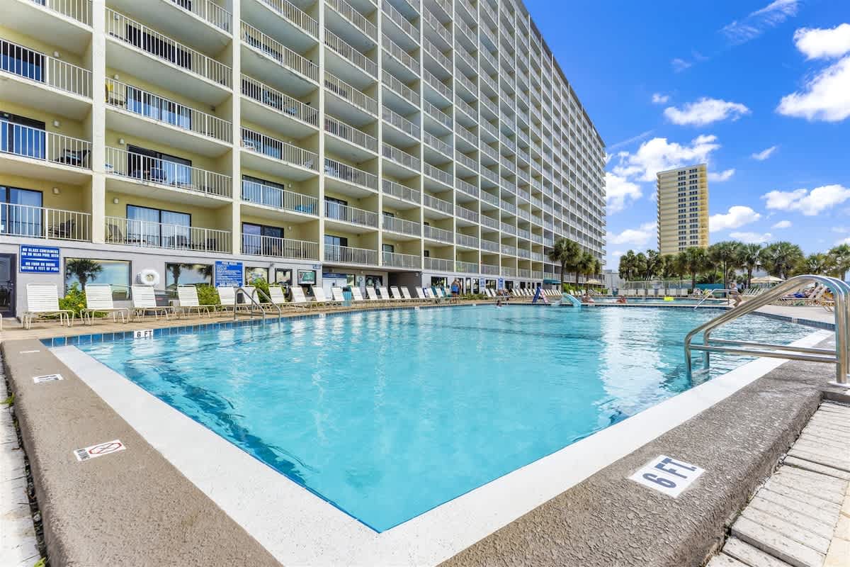The Summit 1006 – Poolside view of The Summit 1006, featuring a large swimming pool and balconies on multiple floors.