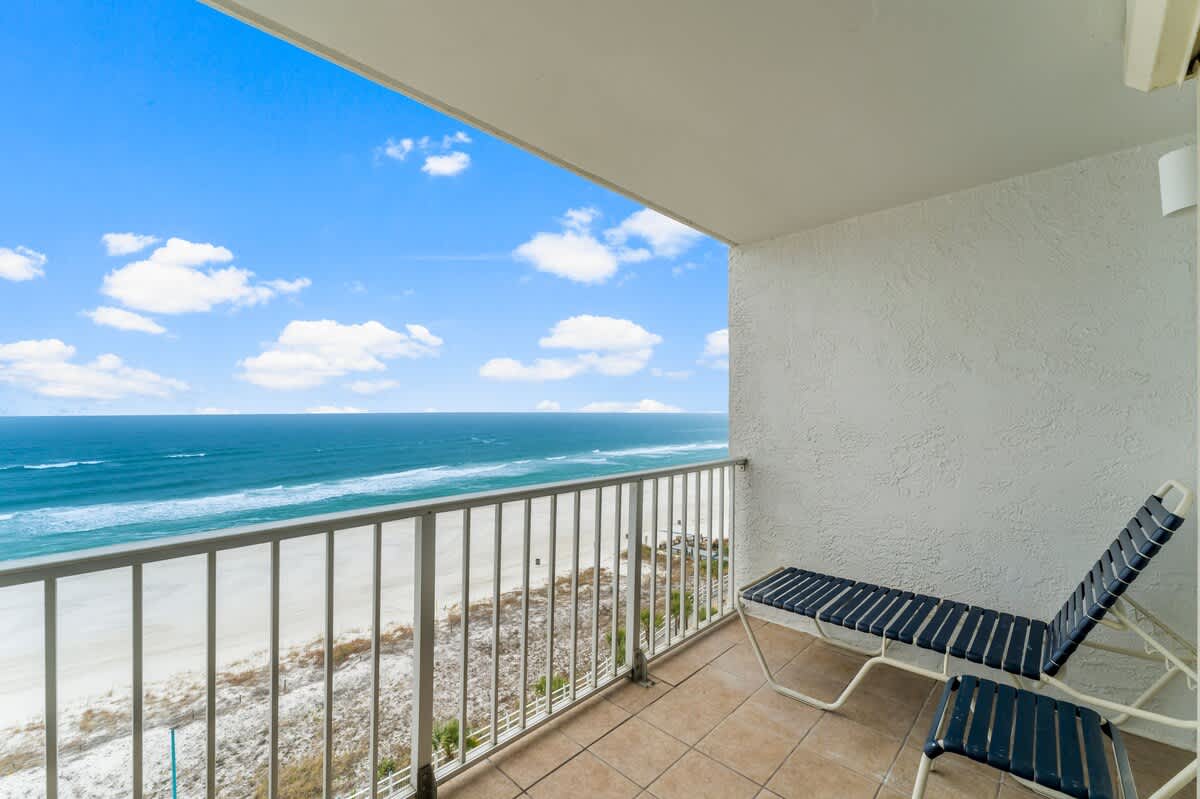 The Summit 1031 – Balcony with ocean view, white sandy beach, and two lounge chairs.