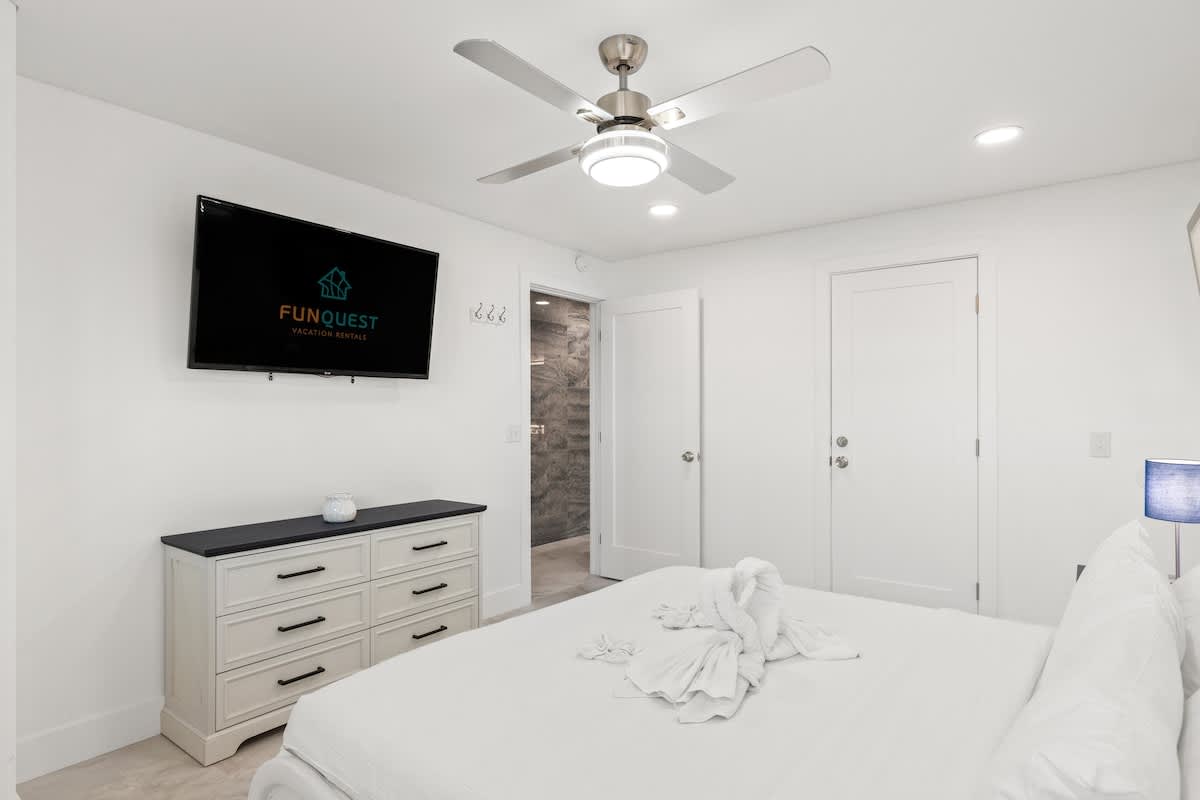 The Summit 306 – Bright bedroom with a queen bed, TV, dresser, and modern decor.