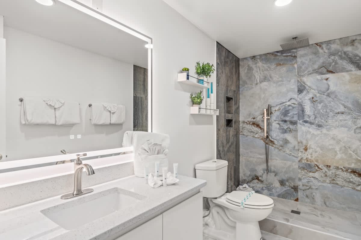 The Summit 306 – Modern bathroom with a glass shower, large mirror, and stylish fixtures.