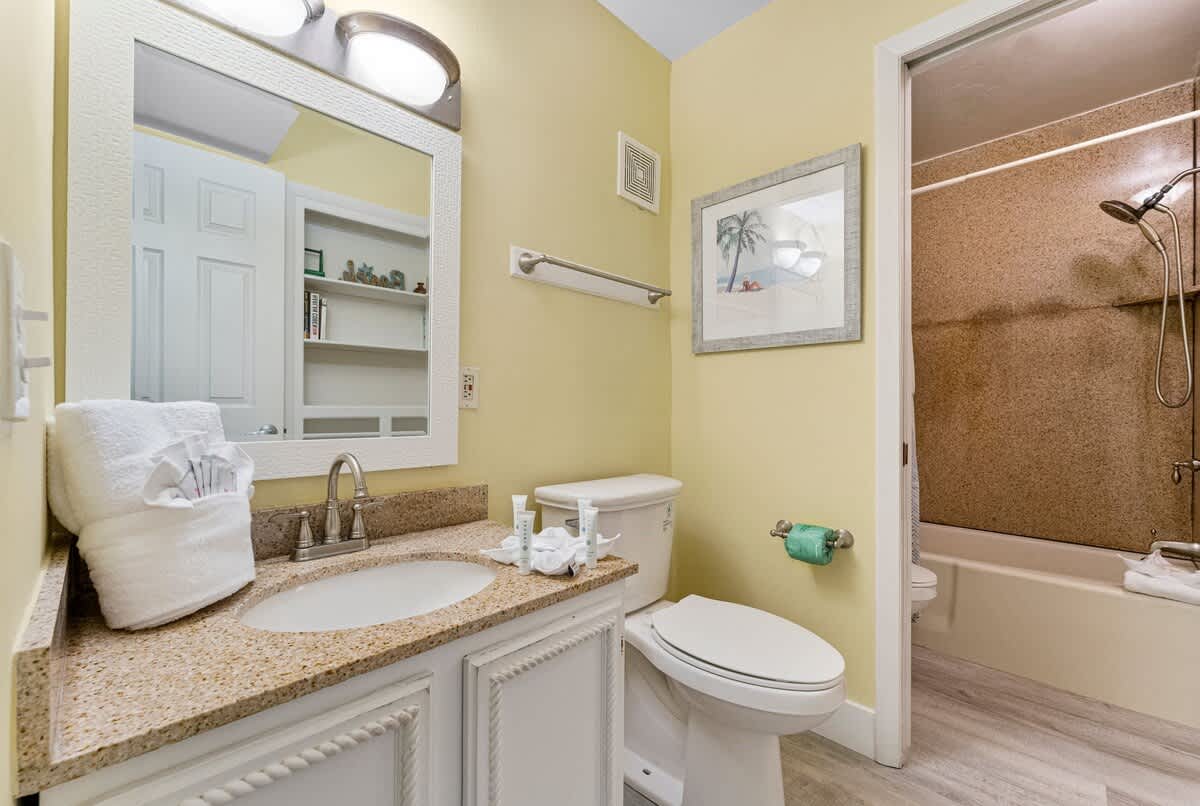 The Summit 1116 – Bathroom with a sink, toilet, shower, and beige walls.