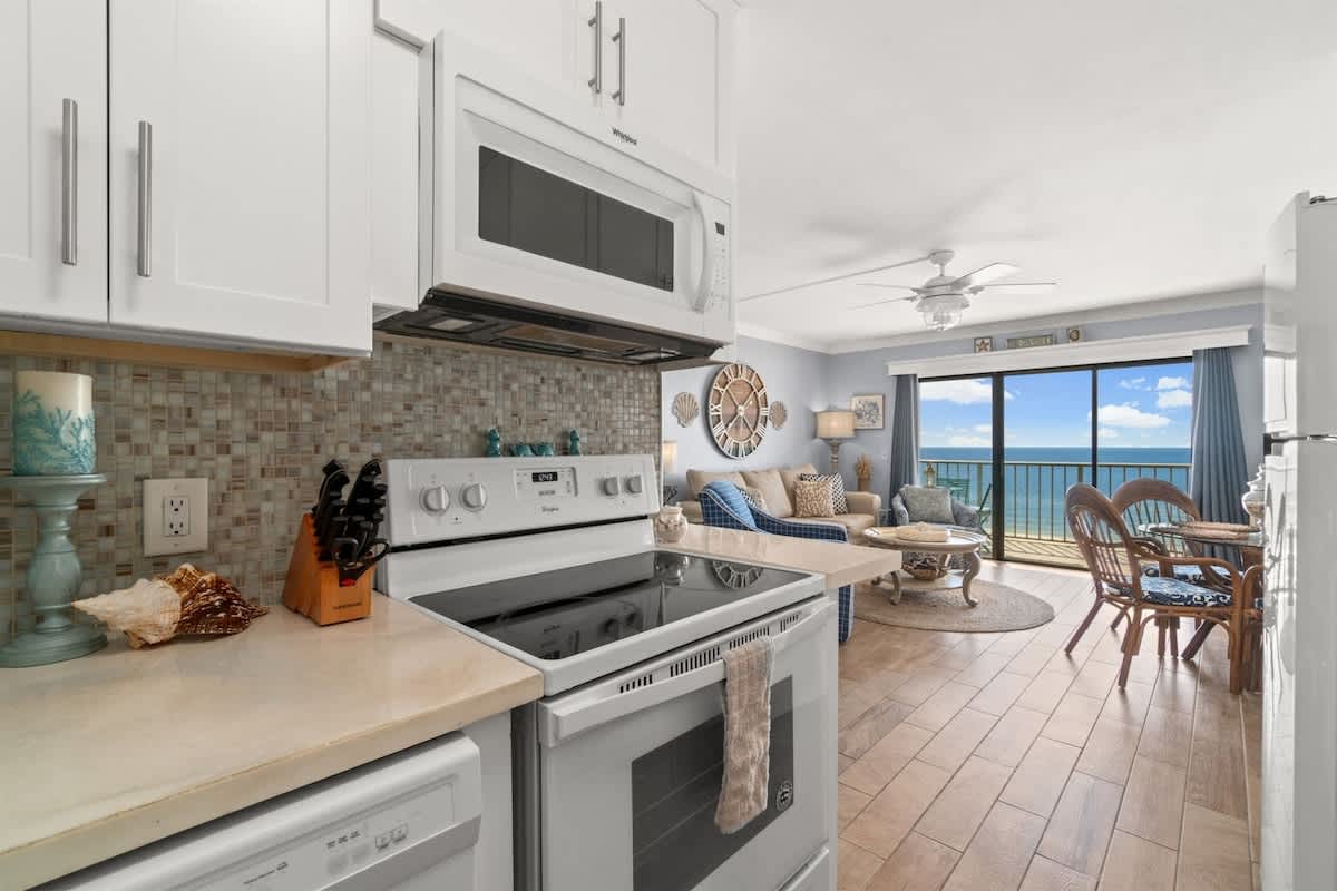 The Summit 502 – Cozy living area with kitchen, ocean view, and seating for four at The Summit 502.