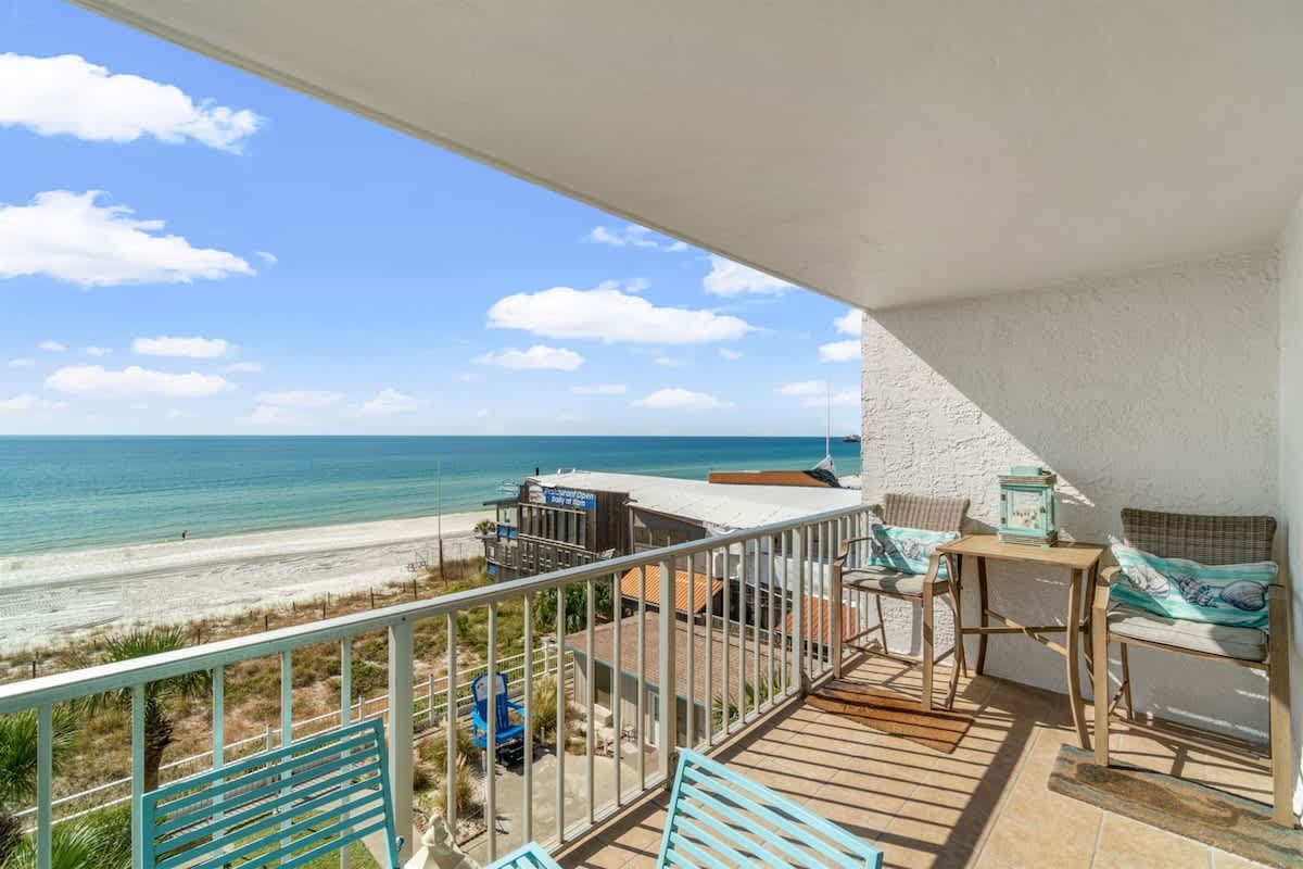 The Summit 502 – Balcony view with two chairs and a table overlooking the beach and ocean.