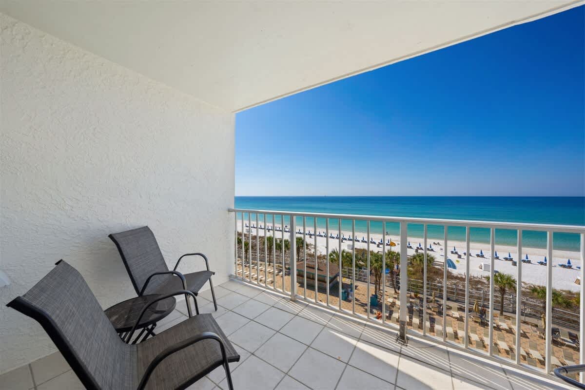 The Summit 615 – Balcony view from a vacation rental featuring two chairs and ocean scenery.