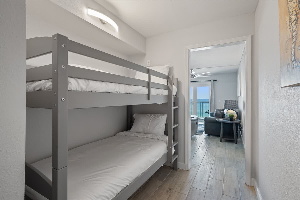 The Summit 615 – Bunk bed in a hallway with ocean view through an open doorway.