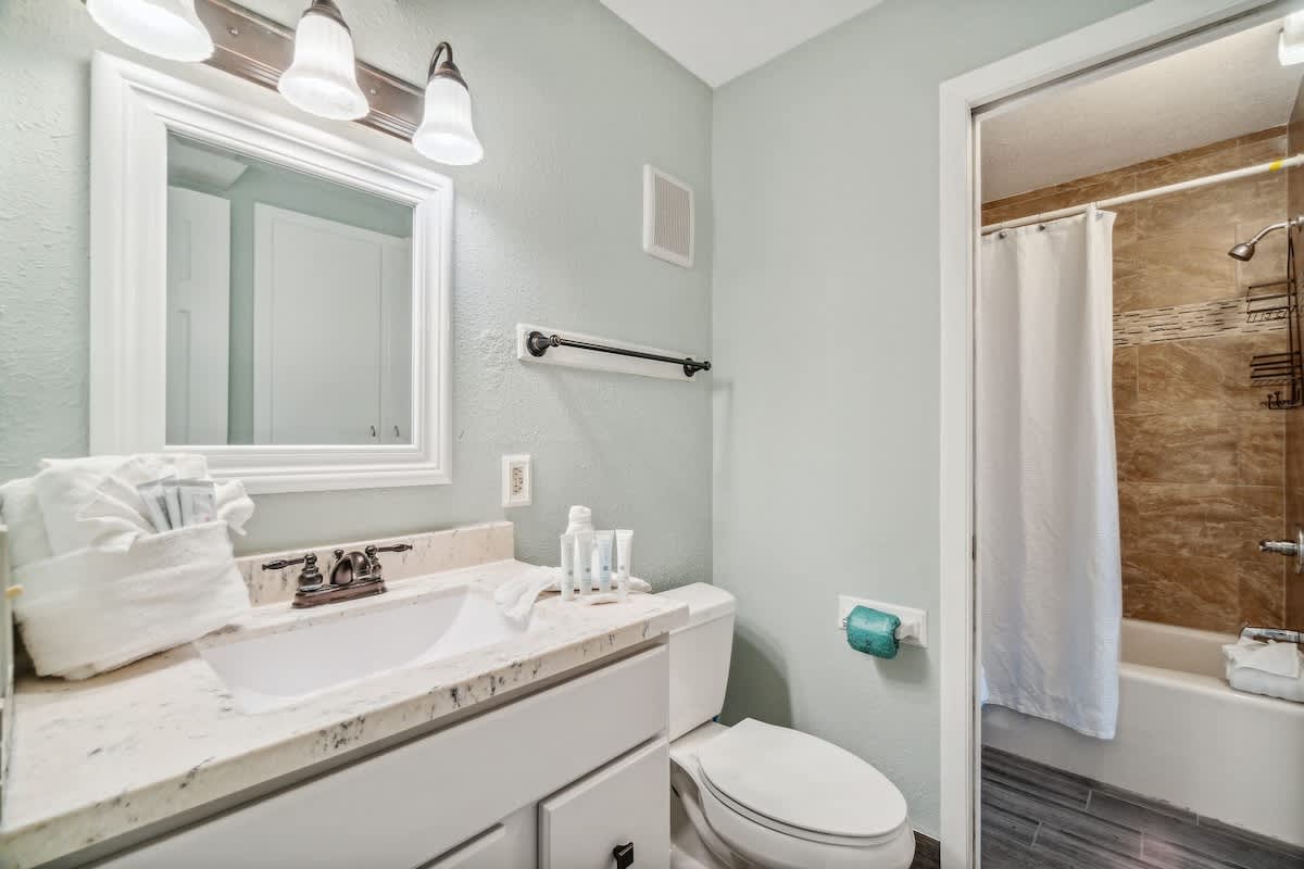 The Summit 108 – Compact bathroom featuring a sink, toilet, shower, and mirror with modern lighting.
