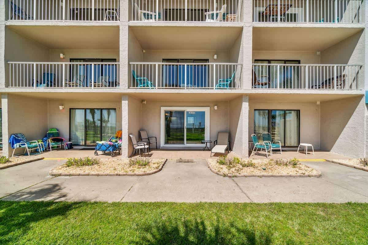 The Summit 108 – Ground-level vacation rental with sliding glass door, patio seating, and balconies above.