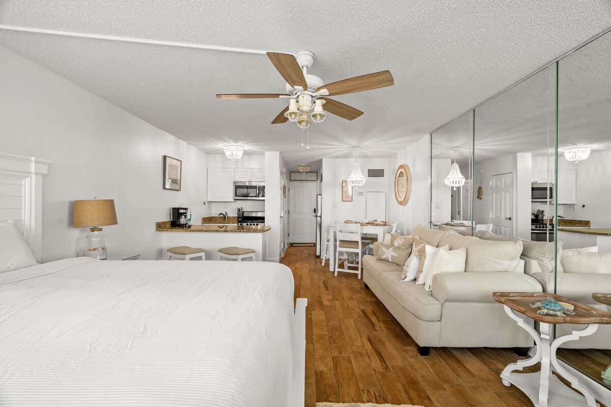 Top Of The Gulf 213 – Studio apartment with a bed, kitchenette, dining area, and a living space with a sofa.
