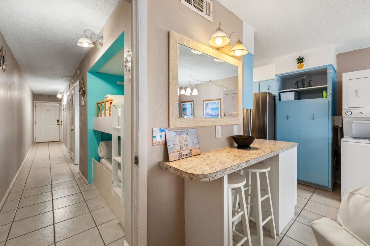 The Summit 1023 – Entryway with a bar area, kitchen appliances, bunk beds, and decorative accents in a vacation rental.