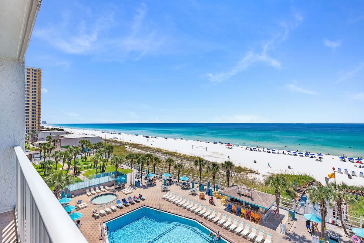 The Summit 616 – Ocean view from balcony showing pool area, beach, and palm trees at The Summit 616.