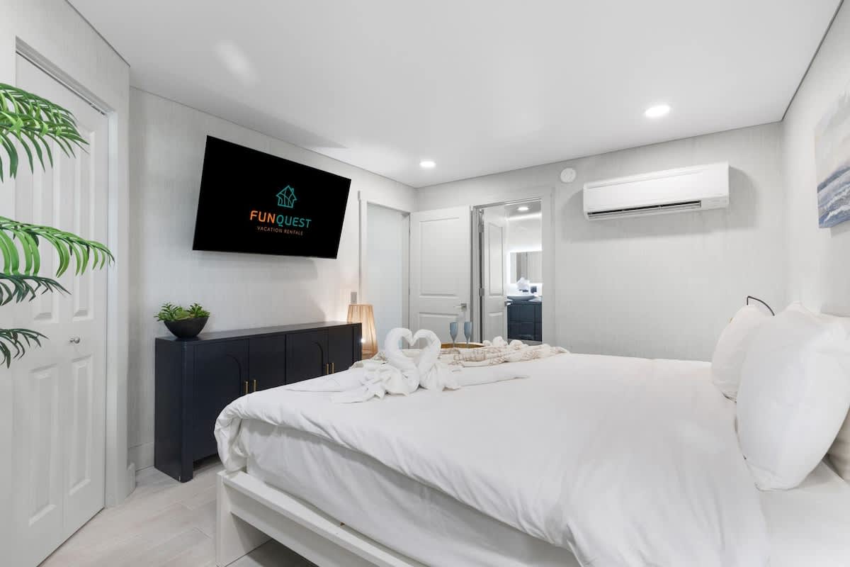 The Summit 616 – Cozy bedroom with a bed, TV, dresser, and en-suite bathroom.