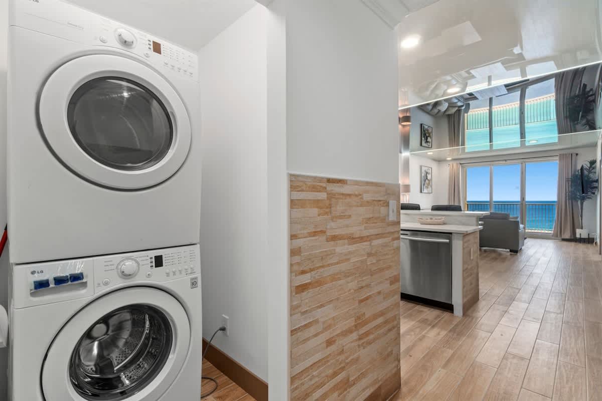 Ocean Villa 1302 – Laundry machines next to a bright open living area with ocean views and modern kitchen features.