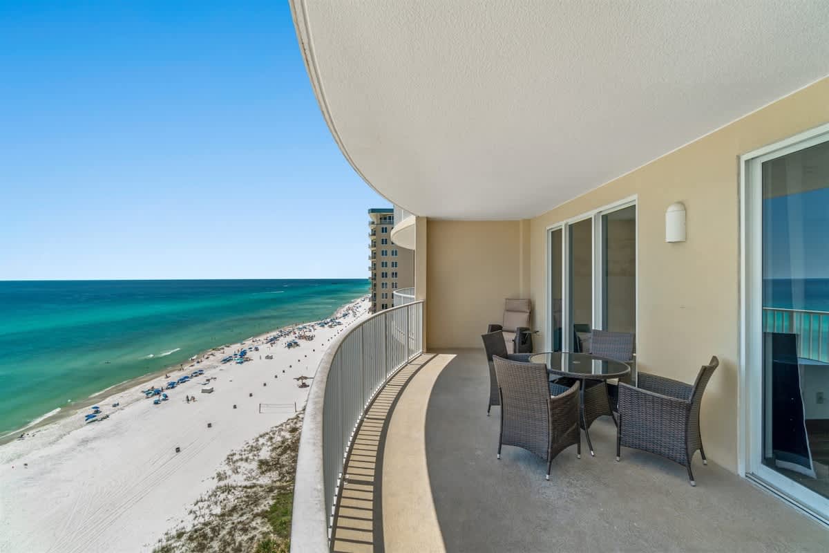 Ocean Villa 1302 – Balcony with outdoor dining set overlooking beach and ocean view.