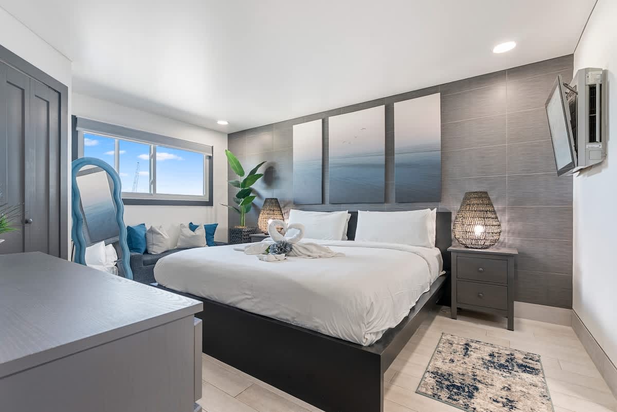The Summit 1205 – Cozy bedroom featuring a large bed, gray décor, artwork, and a window with a view.