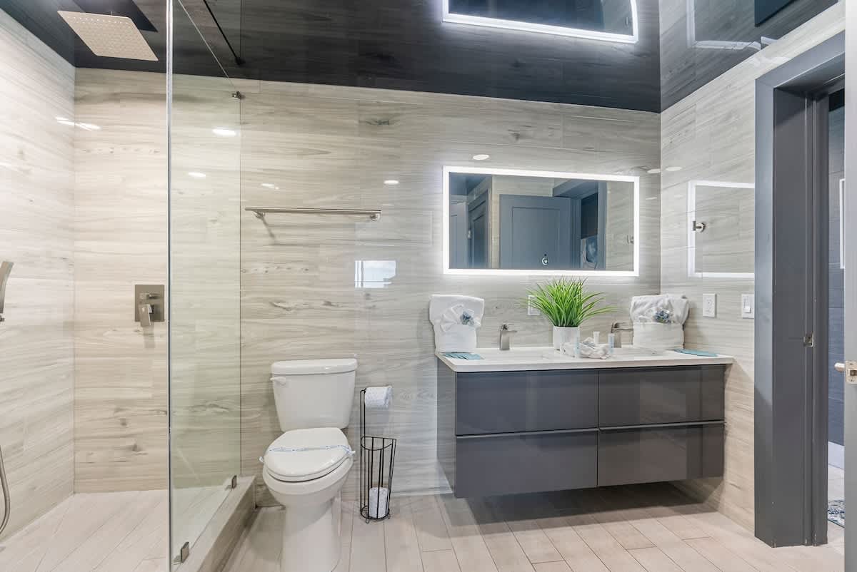 The Summit 1205 – Modern bathroom featuring a walk-in shower, double vanity, and neutral tile design.
