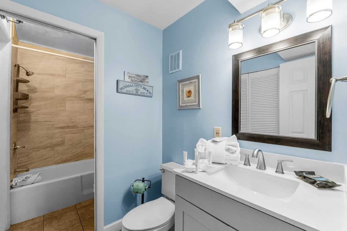 The Summit 1123 – Bathroom with blue walls, sink, mirror, bath/shower combo, and decorative accents.