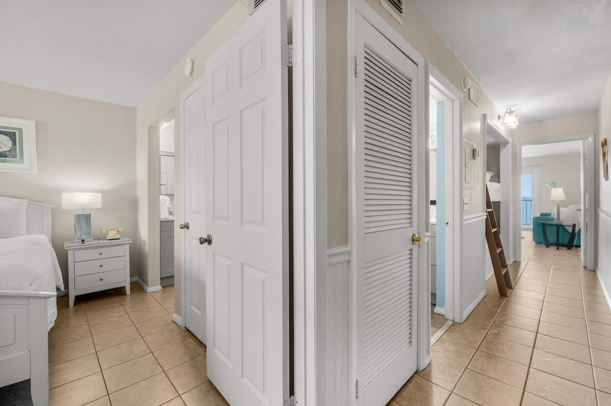 The Summit 1123 – Interior hallway of vacation rental with white doors, tile flooring, and light-colored walls.