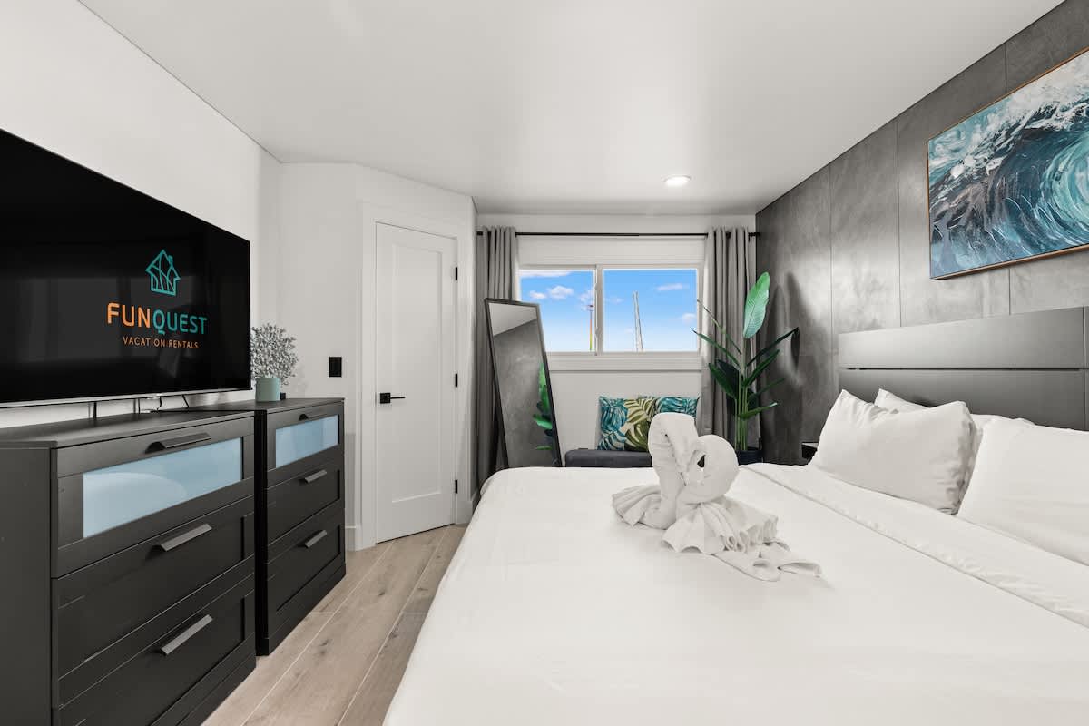 The Summit 1305 – Bedroom with two beds, a TV, a mirror, and a window view.