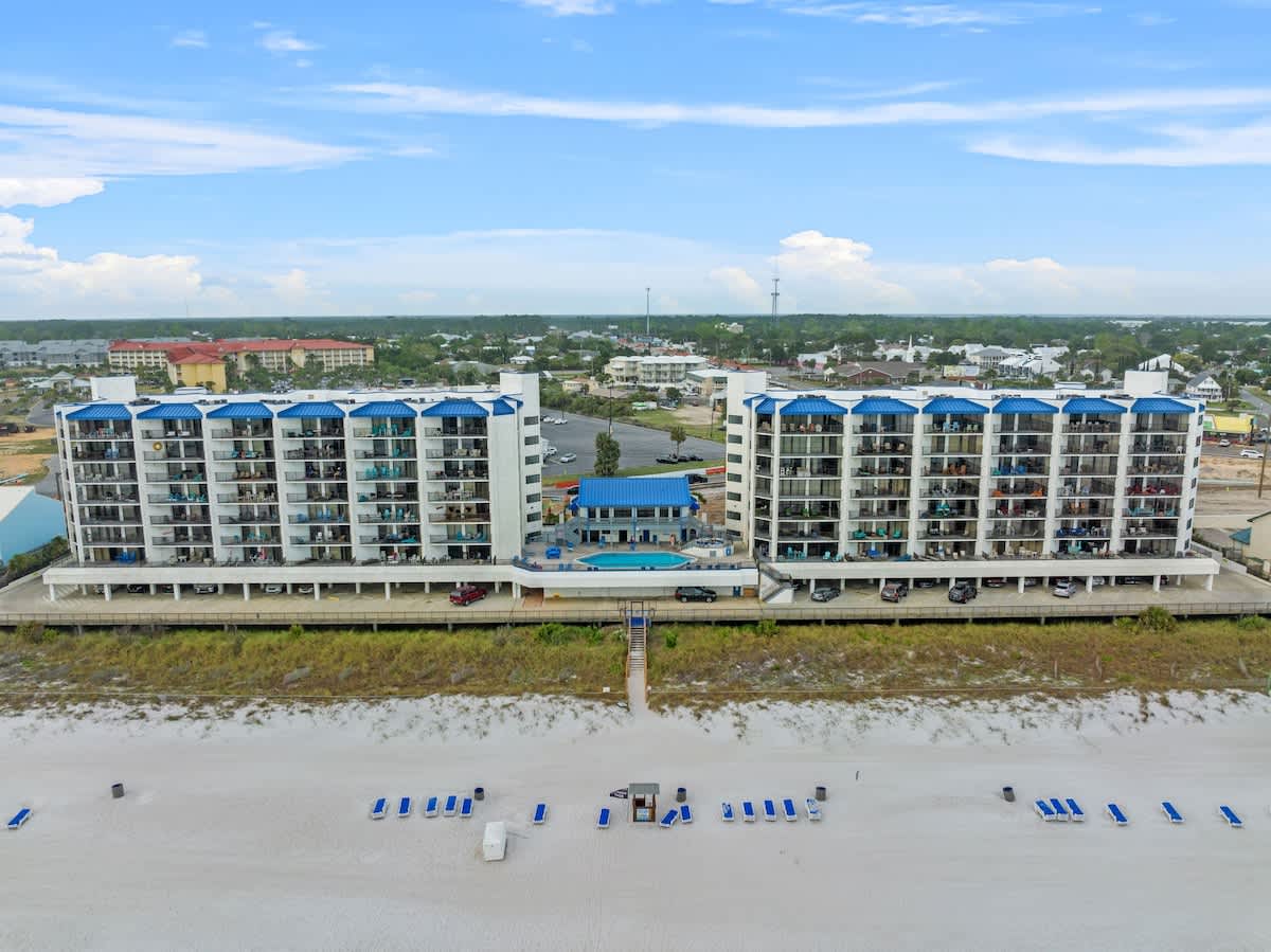 Aquavista 804E – Aerial view of Aquavista 804E, showing beachfront condos, pool area, and white sand beach with lounge chairs.
