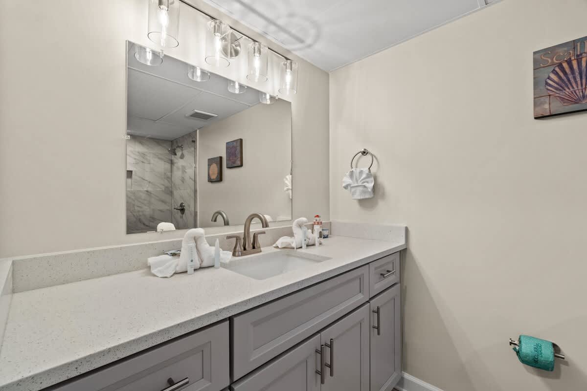 Aquavista 804E – Modern bathroom with double sink, large mirror, and tiled walk-in shower.