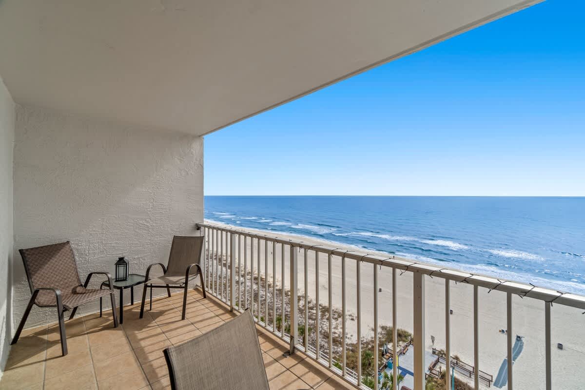 The Summit 1213 – Balcony with two chairs, table, and ocean view at "The Summit 1213.