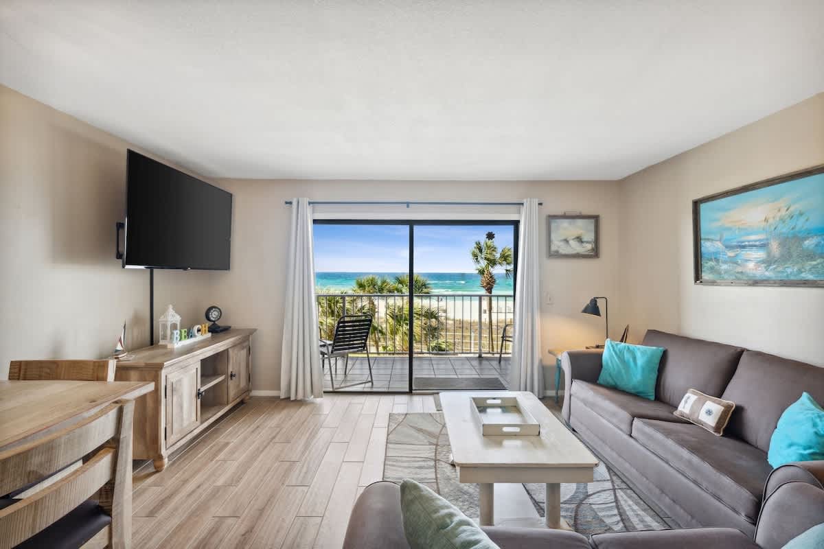 The Summit 307 – Living room with ocean view, balcony access, TV, and comfortable seating.