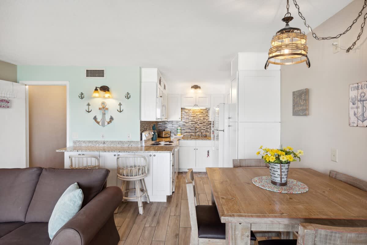 The Summit 307 – Living area with kitchen, dining table, and nautical decor. Light wood floors and modern appliances.