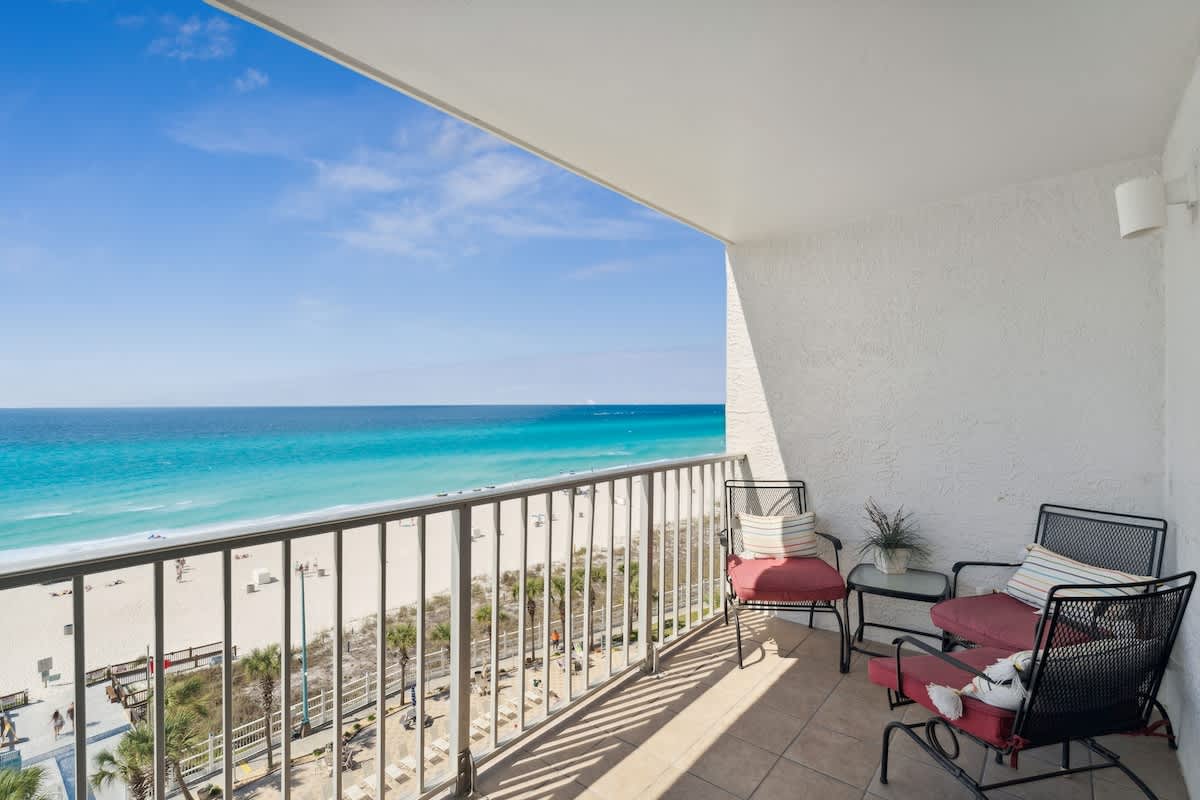 The Summit 817 – Balcony with two chairs, sea view, and sandy beach below.