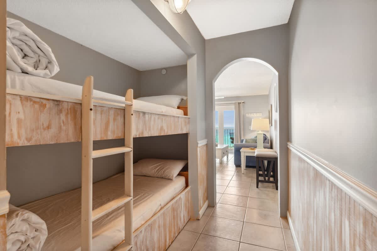 The Summit 817 – Bunk beds in a hallway leading to a living area with ocean views.