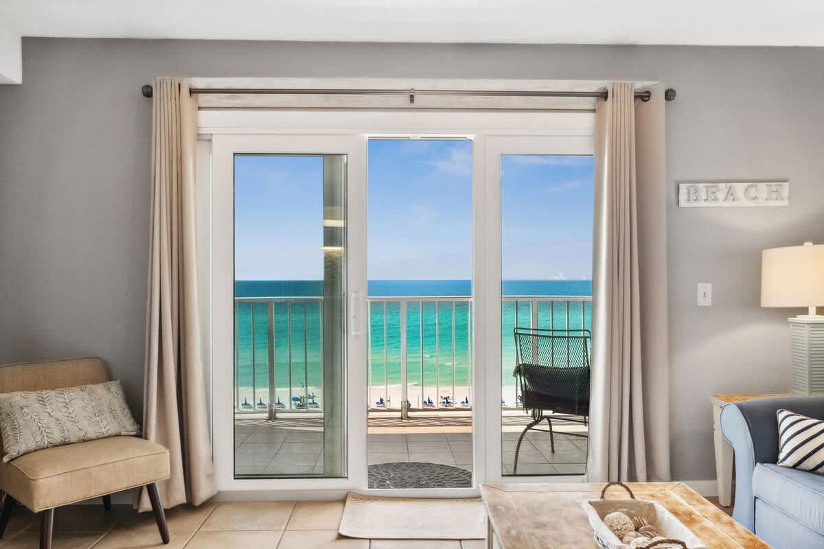 The Summit 817 – Living room with beach view, sliding doors, armchair, and coastal decor.