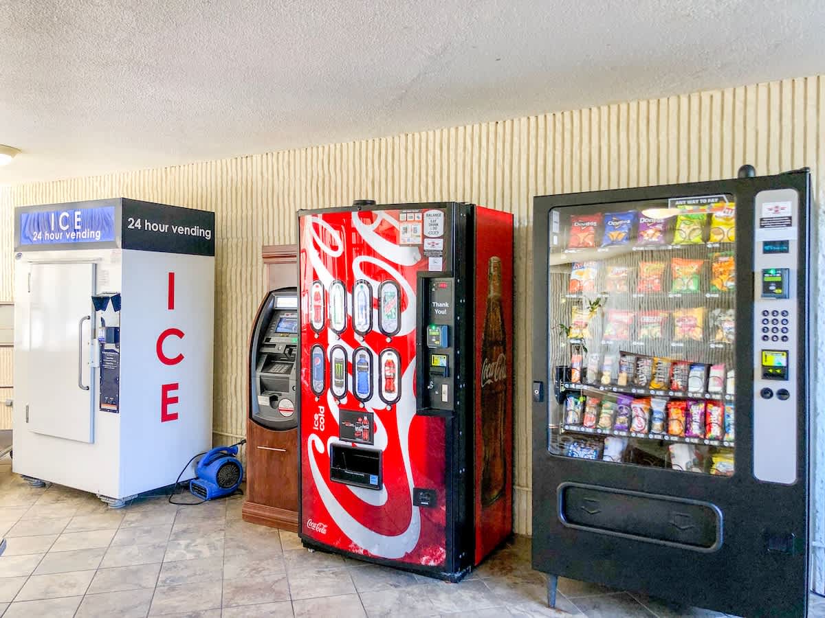 Top Of The Gulf 704 – Vending machines and an ice machine in a tiled corridor area.