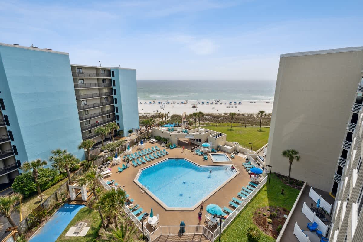 Top Of The Gulf 704 – View of pool area, beach, and nearby buildings from balcony of Top Of The Gulf 704.