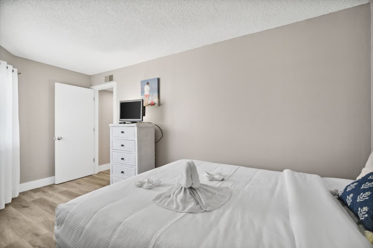 Moondrifter 502 – Bedroom with a bed, dresser, TV, and decorative towel art on the bed.