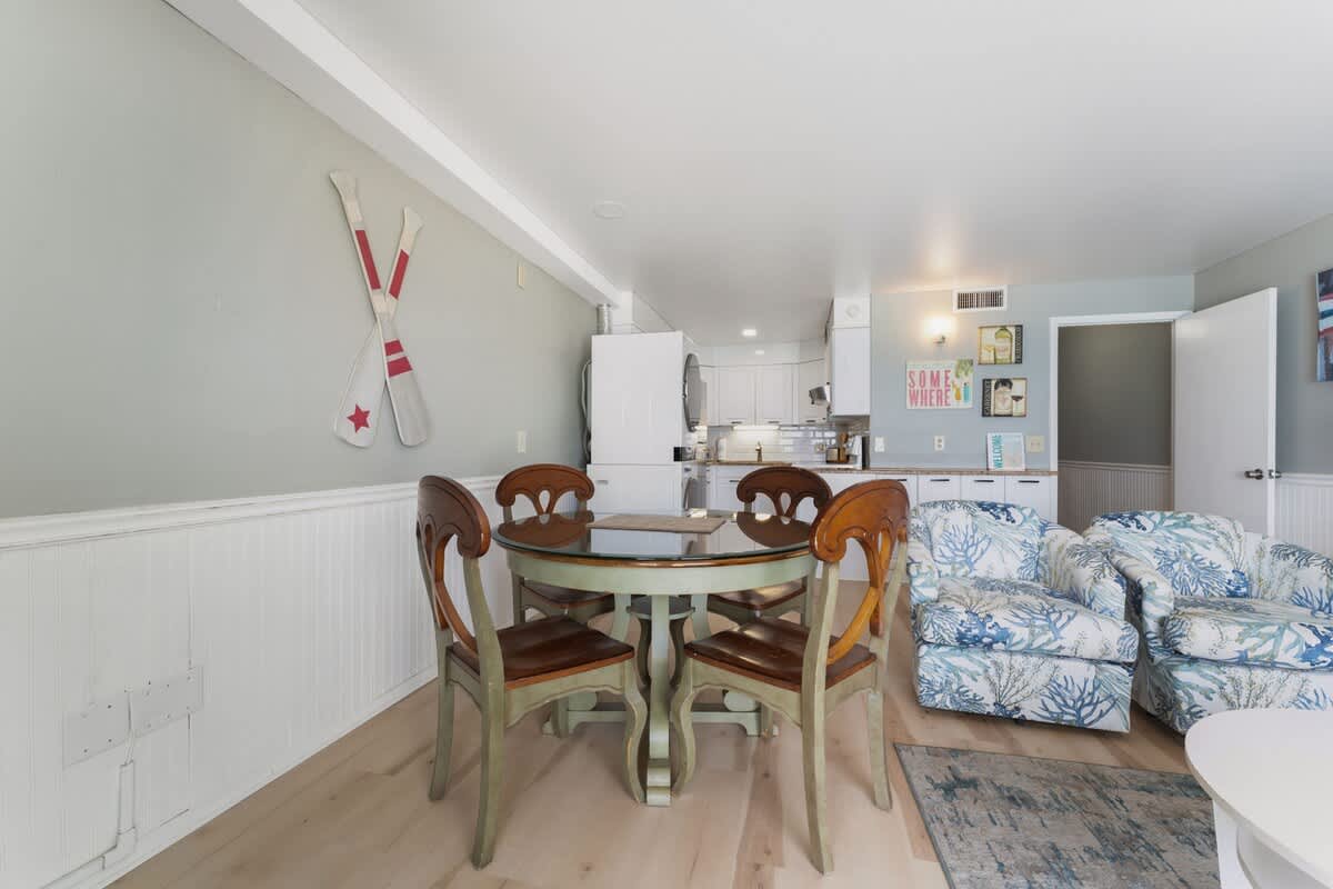 The Summit 1222 – Interior view of a dining area with a round table, four chairs, and two patterned armchairs.