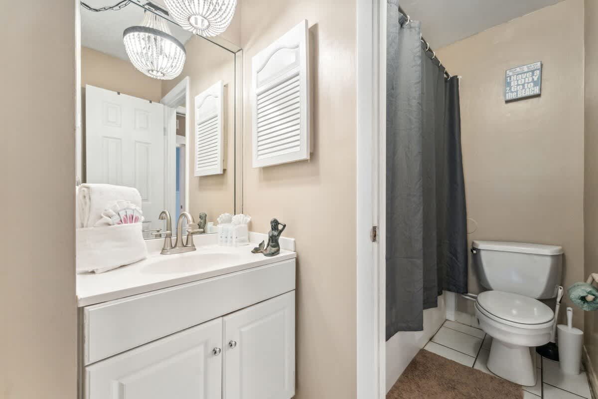 The Summit 725 – Bathroom with a sink, mirror, shower curtain, toilet, and decorative accents.
