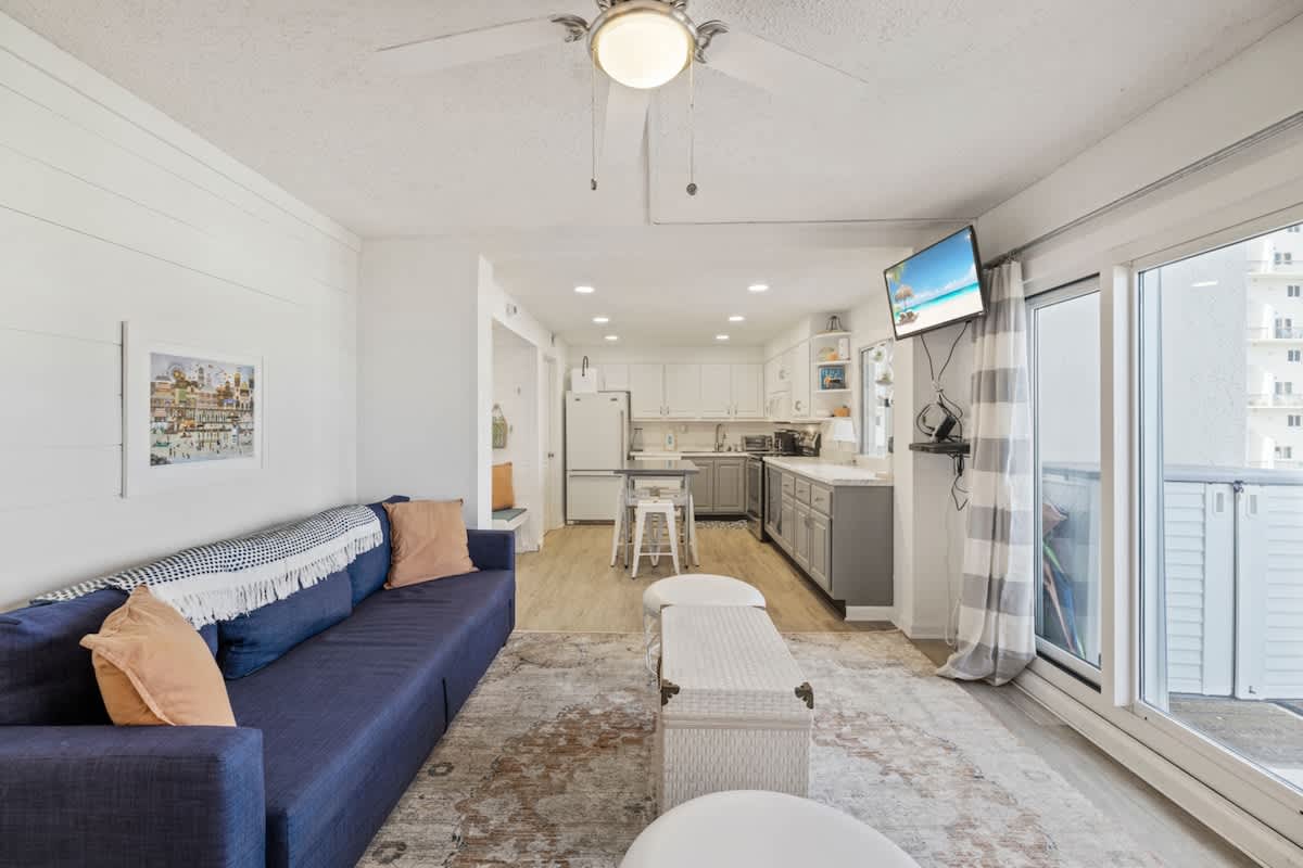 Pinnacle Port 304A – Open living area with kitchen, sofa, and TV; large windows with outdoor view.