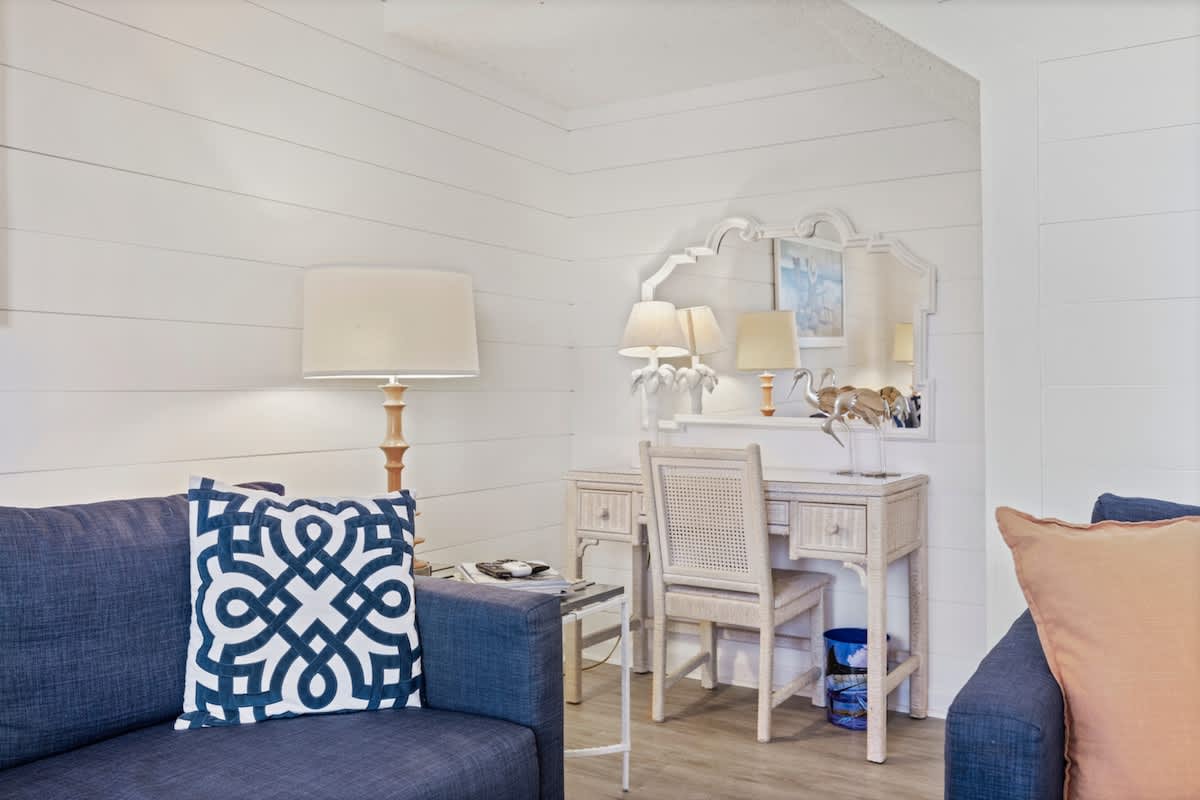 Pinnacle Port 304A – Living room with two sofas, decorative pillows, lamp, and a writing desk with a mirror.