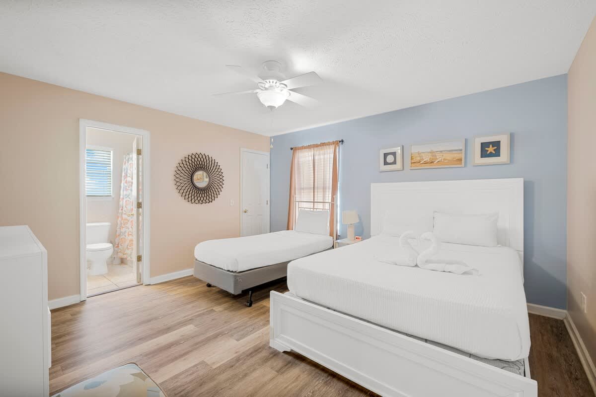 126 Seagrass Way – Bedroom with two beds, a closet, ceiling fan, and a bathroom door in the background.