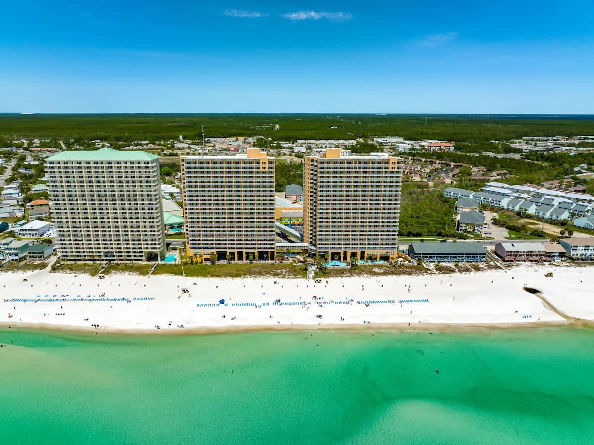 Splash 804E – Aerial view of three high-rise condos along a white sandy beach and turquoise water.