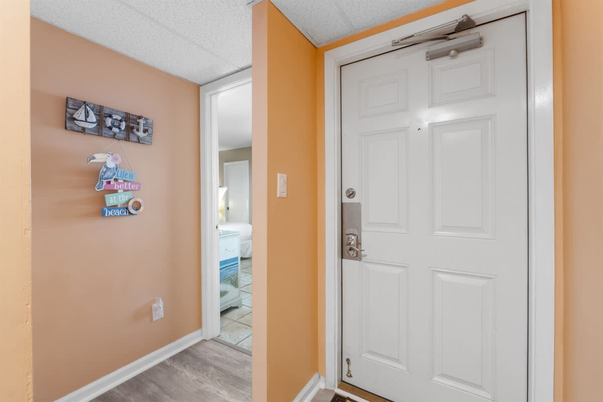 Moondrifter 207 – Entryway with orange walls, white door, and a view into a bedroom area.