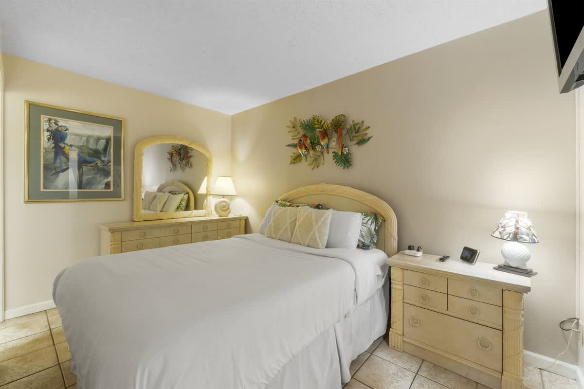 Moondrifter 207 – Cozy bedroom with a queen bed, nightstands, artwork, and a dresser with a mirror.