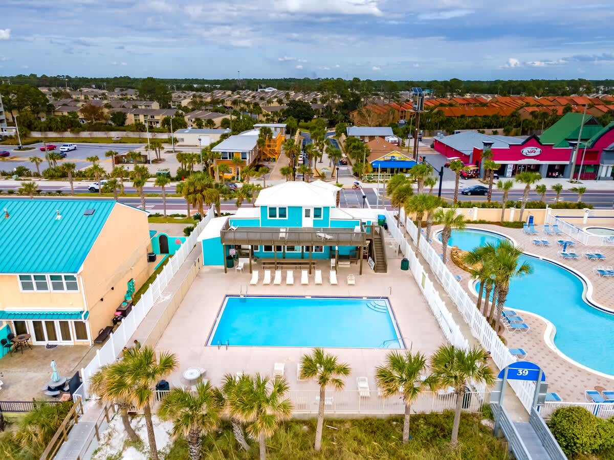 135 Grande Island Blvd – Aerial view of a vacation rental with pools, lounge chairs, and palm trees.