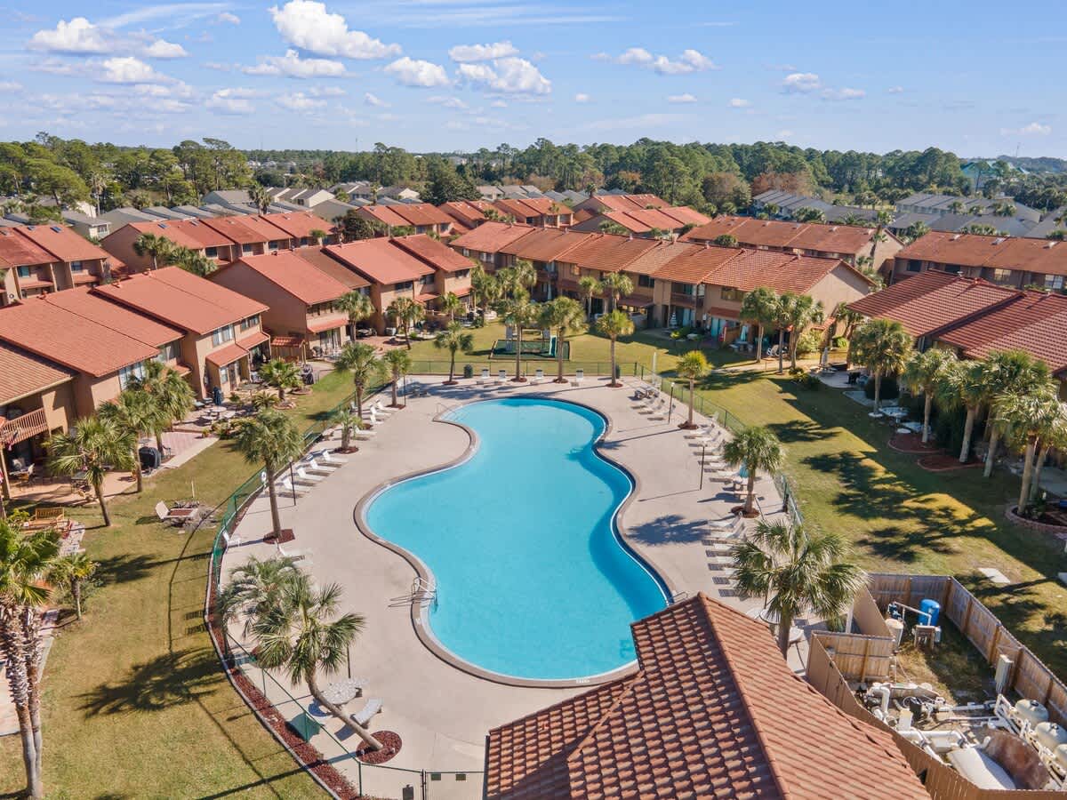 135 Grande Island Blvd – Aerial view of a pool surrounded by rental units and palm trees.