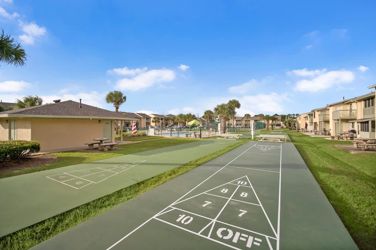 135 Grande Island Blvd – Outdoor recreational area with shuffleboard courts and a swimming pool visible in the background.