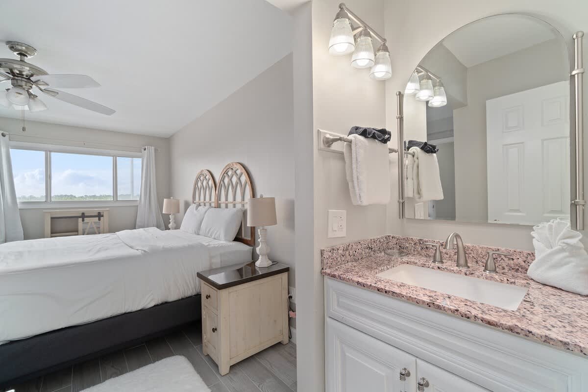 The Summit 529 – Light-filled bedroom with a king bed, ensuite bathroom, and large window view.