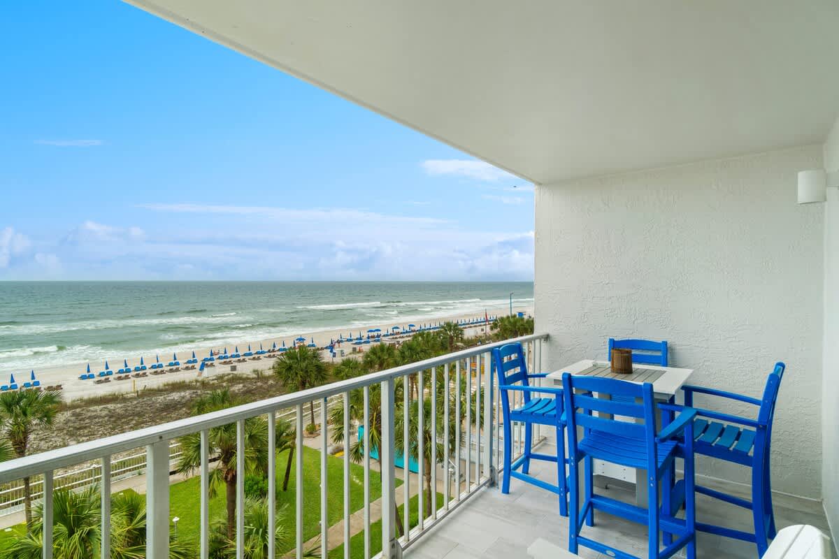 The Summit 529 – Balcony with blue furniture overlooking the beach and ocean.