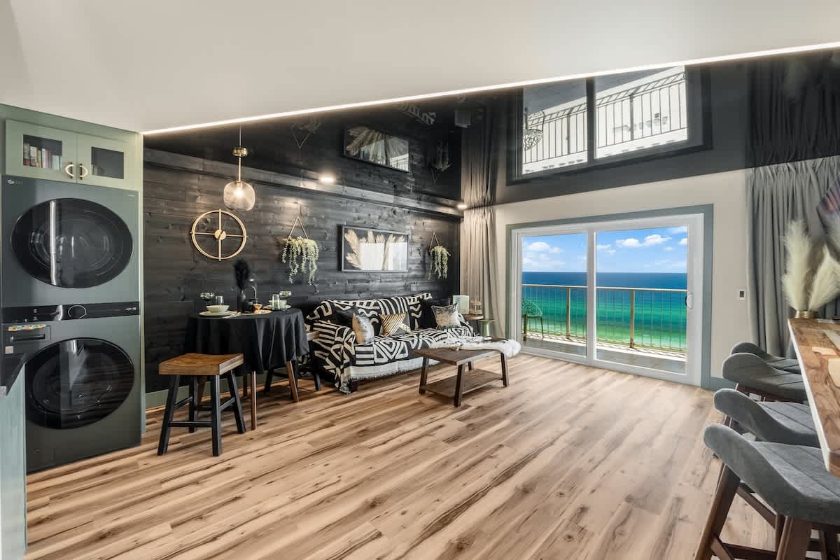 The Summit 1107 – Cozy living area with ocean view, modern furniture, and compact kitchen appliances.