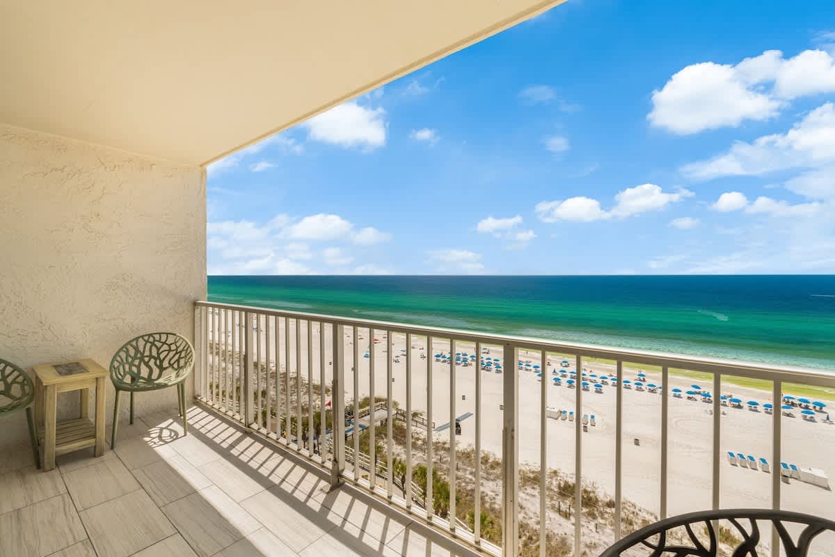 The Summit 1107 – Balcony view of the beach, ocean, and blue sky with seating.