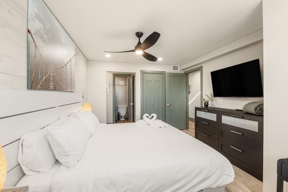 The Summit 1107 – Modern bedroom with a large bed, flat-screen TV, and an en-suite bathroom.