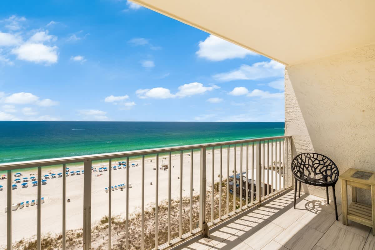 The Summit 1107 – Balcony view from a beachside rental overlooking sandy beach and ocean.